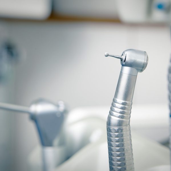 Metallic dentist tools close up on a dentist chair in Dentist Clinic (blue tone)