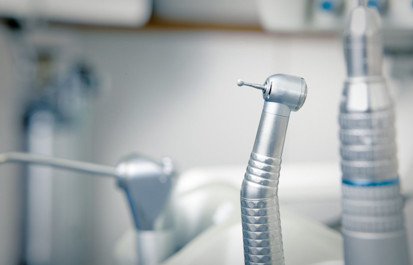 Metallic dentist tools close up on a dentist chair in Dentist Clinic (blue tone)